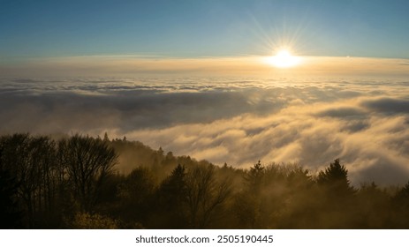 Sunset with clouds, sun rays, and misty valleys. - Powered by Shutterstock