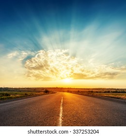 sunset in clouds with sunrays over road to horizon - Shutterstock ID 337253204
