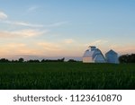 Sunset with cornfield and white barn in background.  LaSalle County, Illinois, USA