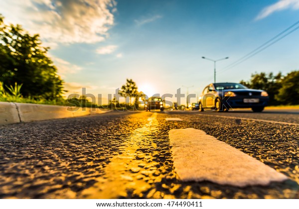 Sunset in\
the country, the cars on the highway traveling toward. Wide angle\
view of the level of the dividing\
line