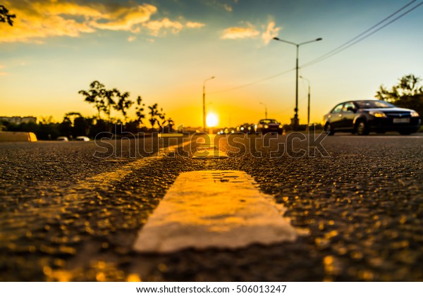 Sunset in the country,\
the stream of cars on the highway. Wide angle view of the level of\
the dividing line
