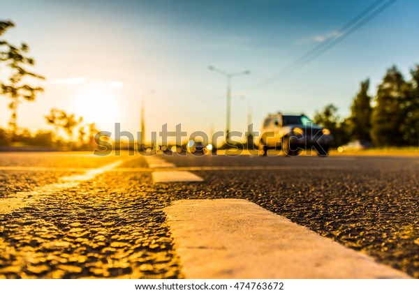 Sunset in\
the country, the stream of cars passing by on the highway. Wide\
angle view of the level of the dividing\
line
