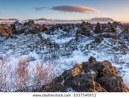 Sunset at Dimmuborgir (dark lave fields) with crater Hverfjalli the background.