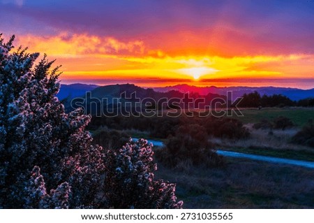 Sunset and dramatic afterglow over Bay Area ridge trail