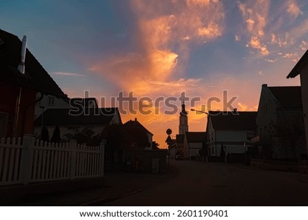 Sunset with dramatic clouds and a church silhouette at Alburg, Straubing, Bavaria, Germany