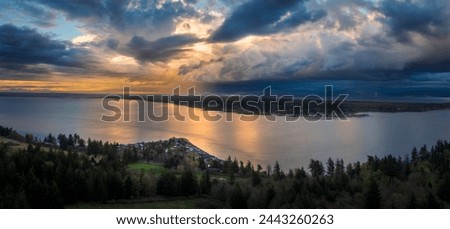 Sunset and Dramatic Clouds Over Hale Passage From Lummi Island, Washington. Aerial drone view of Lane Spit and Gooseberry Point across Hale Pass in the Salish Sea area of western Washington state.
