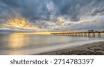 Sunset with dramatic clouds in sky over the Gulf of America formerlly the Gulf of Mexico at the Venice Fishing Pier in Venice Florida USA