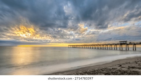 Sunset with dramatic clouds in sky over the Gulf of America formerlly the Gulf of Mexico at the Venice Fishing Pier in Venice Florida USA