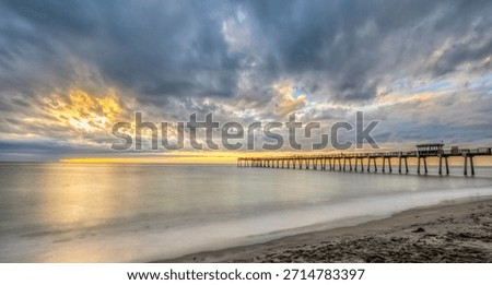 Sunset with dramatic clouds in sky over the Gulf of America formerlly the Gulf of Mexico at the Venice Fishing Pier in Venice Florida USA