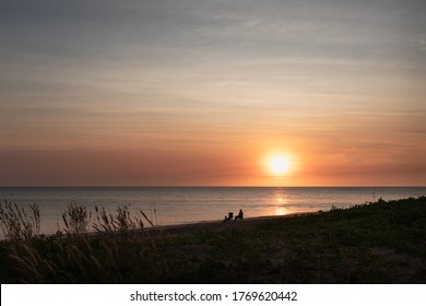 Sunset At Dundee Beach. Person At The Beach Sitting On A Camping Chair, With Camping Gear, Looking At The Ocean. Fishing Destination Near Darwin, Northern Territory NT, Australia