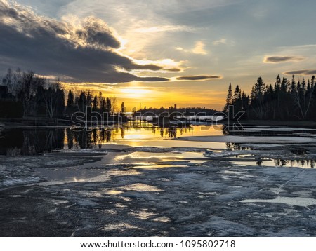 A sunset during springtime across an inlet with ice thawing at Lac Saint-Jean in Alma, Quebec