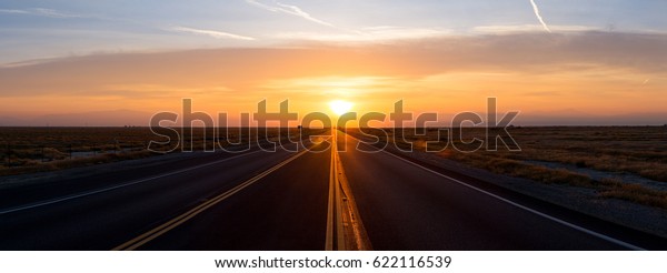 Sunset at the\
end of an empty road in\
California