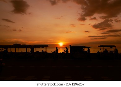 Sunset Evening Street Foods Night Market. Silhouette People Standing Beach. Car Driving On Road.