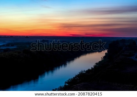 Sunset at evening sunrise over the river.Morning dawn.Late evening.Evening sunset.
Evening golden hours and nightfall.Glowing pink sky.Heavenly horizon line.Night skyline with red clouds.View nature