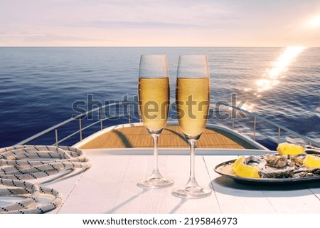 Sunset. Exotic country voyage. Champagne flutes glasses on deck of luxury cruise ship during honeymoon holidays. Love, travel, vivid impressions. Design for wallpaper, poster