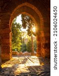 Sunset at the gate of the wall and the gardens of the Alcazaba in the city of Malaga, Andalusia. Spain. Medieval fortress in arabic style