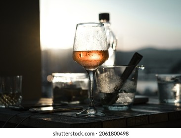 Sunset Glass Of Wine, Ice , Bottle Of Water, Sun, Grey Dark Tones, Against Light Shot, Evening Apperitive Drink, Sun Blink In A Glass