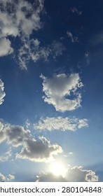 Sunset glitter through fluffy cloudscape in June,blue,breeze,scorching, ray power.