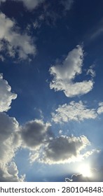 Sunset glitter through fluffy cloudscape in June,blue,breeze,scorching, ray power.