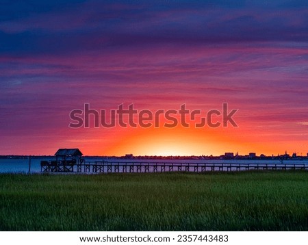 Sunset glowing in purple and pink clouds at pitt street bridge in Mount Pleasant, South Carolina.