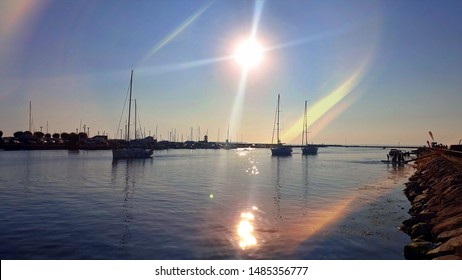 Sunset   in Harbor water wave reflection sky scape seascape   sea stone birds on sky  light sun boat  in port colorful  summer nature background  