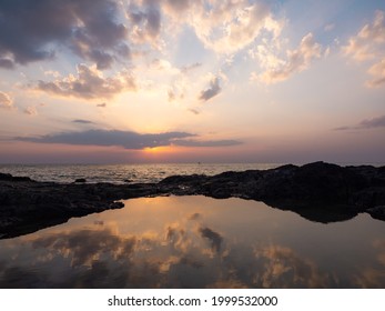 Sunset At The Horizon. Dramatic Clouds Sky At Sea. Heavenly Twilight Sky. Sunrays Sunbeams Shine Through Dramatic Clouds Above The Ocean. Reflection Of Golden Light Shines On The Water Surface.