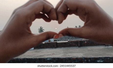 sunset image between hands with love shape