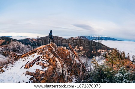 Sunset with inversion. Hiker, who is watching this breathtaking beautiful scenery. Travel destination. Tatry in the background. Winter inversion clouds