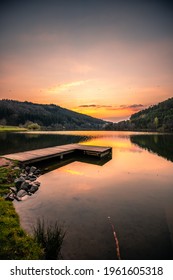 Sunset at the lake, a beautiful summer evening by the water with pale in the sun, reflection in the water, a natural landscape

