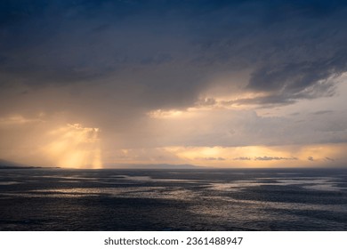 Sunset landscape between the clouds over the horizon of the sea. Golden reflections in the clouds and the sea. - Powered by Shutterstock