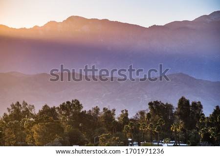 Sunset Landscape in Coachella Valley, with sun rays shining on the rocky ridges of the San Jacinto mountains, Palm Desert, California