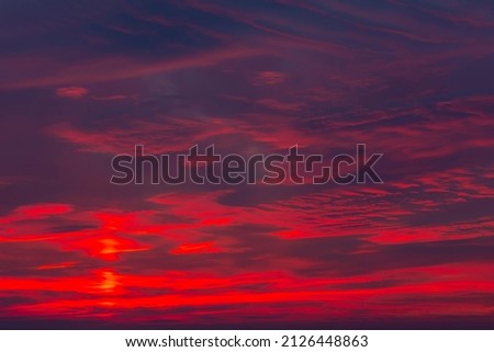 Sunset layers of clods with shades of red, yellow dark blue light gray mutable shapes beautiful sky horizontal photo, photograph just after sunset