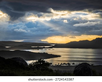 Sunset light breaking through storm clouds over Lake Maree in Scotland