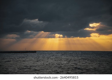 Sunset light rays through clouds over the ocean