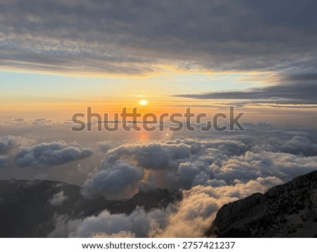 Sunset light spreading over dense clouds above the slopes of Babadag in Oludeniz. The image conveys the concept of open sky atmosphere and high natural space.