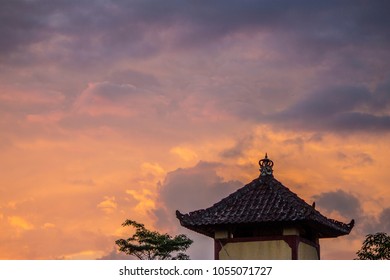 Sunset lights among the clouds on the roof of an oriental temple in Ubud, Bali, Indonesia