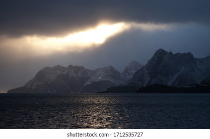 Sunset Lit Sky Over Foreboding Mountain Island with Ominous Clouds - Shutterstock ID 1712535727