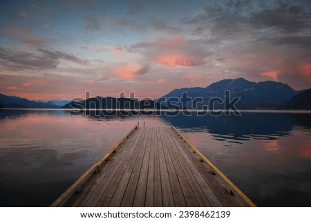 Sunset with Long Pier Leading Out into Water. Harrison Lake, BC, Canada area is breathtaking with beautiful coves, beaches and islands, waterfalls, coniferous forests and snow-capped mountains.