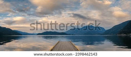 Sunset with Long Pier Leading Out into Water. Harrison Lake, BC, Canada area is breathtaking with beautiful coves, beaches and islands, waterfalls, coniferous forests and snow-capped mountains.