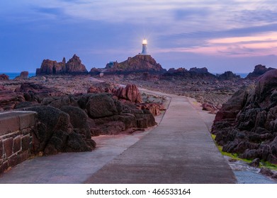 Sunset and low tide at the La CorbiÃ¨re Lighthouse in St. Brelade, Jersey, Channel Islands, UK.