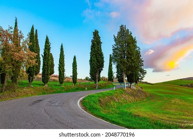  Sunset. The Magnificent Italian Province Of Tuscany. Fields And Hills Are Covered With Light Fog. Evening Twilight. The Winding Road To The Farm 