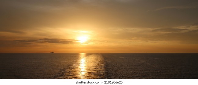 Sunset In Malacca Strait With A Ship In Horizon