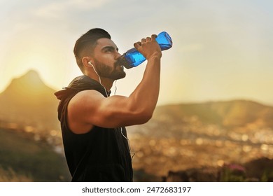 Sunset, man and drinking water with earphones in countryside for fitness and exercise in summer. Mountain, athlete and bodybuilder in evening for wellness or rest with podcast or radio in Los Angeles - Powered by Shutterstock