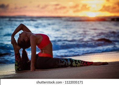 Sunset meditation. Young active woman stretching in yoga pose on sea beach to keep fit and health. Healthy lifestyle, flexibility training, sport activity in sport camp on summer family holiday.
 - Powered by Shutterstock