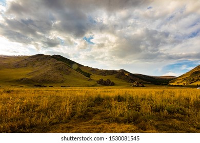 Sunset at the Mongolian steppe, The sun goes down at Mongolia , Sunset Landscape photography in the Mongolian steppe at Arhangai-Aimag. Blue sky with white clouds and yellow grass in forground