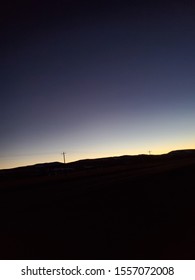 Sunset with a mountain background and power lines slowly disappear 