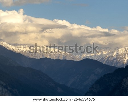 Sunset mountain landscape as seen from Killar village in Pangi Valley, Himachal Pradesh, India. Clouds on snow capped mountain peaks during sunset. Nature, Travel concept 