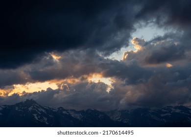 Sunset In The Mountains Behind Big Threatening Clouds