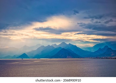 Sunset in the mountains. Dramatic colorful clouds over blue hills in Antalya, Turkey. Misty hills mountains. A beautiful mountain landscape in blue tonality.