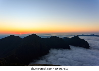 Sunset in the mountains over the clouds